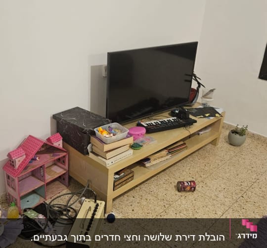 טלוויזיה על שידה עם צעצועים וספרים